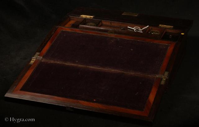WB484: Writing slope in rosewood  with mother of pearl inlay circa 1835. This is a writing slope of good quality. The outside is veneered in saw cut rosewood inlaid with mother of pearl and white metal. The inlay is executed with precision.   Working lock and key.    Enlarge Picture